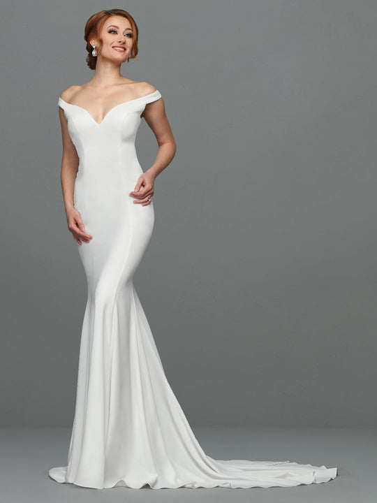 A woman in the Avery Austin TH-Hazel ivory off-the-shoulder mermaid wedding dress stands against a plain gray background, smiling softly with one hand on her hip.