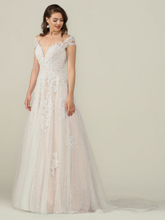 A woman poses gracefully against a beige background in the Piper wedding dress by Avery Austin, featuring an off-the-shoulder fitted lace bodice and a flowing ivory/champagne A-line skirt with train.