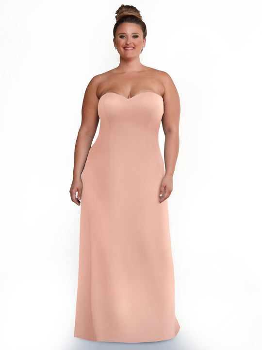 A woman with light skin and brown hair in a bun wears the Avery Austin 83044 strapless sweetheart A-line dress in mauve, smiling against a plain white background.