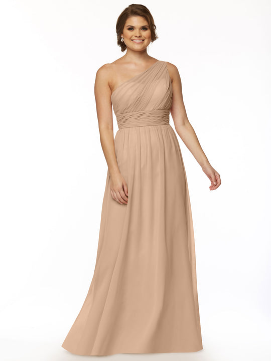 A woman models Avery Austin’s 80047 dress in Buff—a long, one-shoulder chiffon gown with a fitted, ruched bodice and flowing skirt—posing against a plain white background for a modern take on elegance.