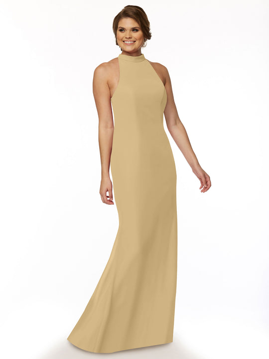 A woman stands and smiles in the Avery Austin 80068 Champagne sleeveless, floor-length halter bridesmaid dress with an open back, set against a white background.