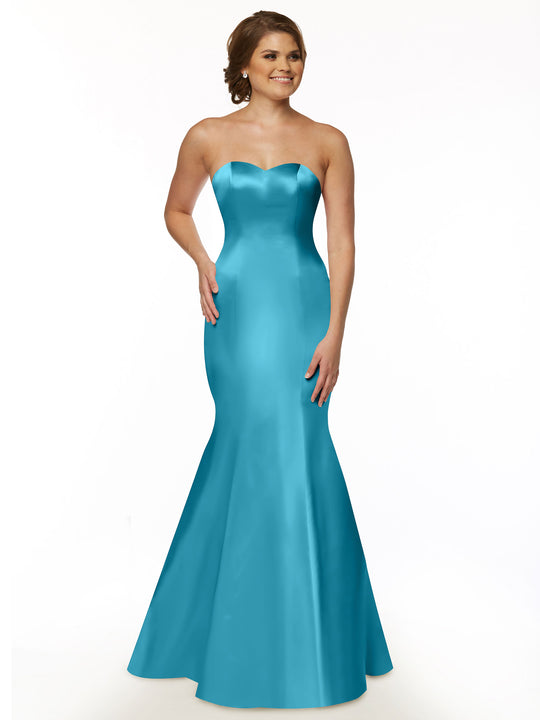 A woman with short brown hair smiles in the Avery Austin 80072, a turquoise fit and flare mermaid gown with a strapless sweetheart neckline, posing against a plain white background to showcase its elegant silhouette.
