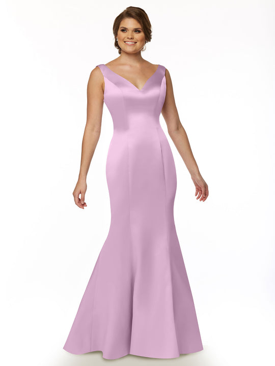 A woman smiles in the Avery Austin 80078, a sleeveless lavender fit and flare gown with a V-neckline, flared skirt, and ruffled back, standing against a plain white background.