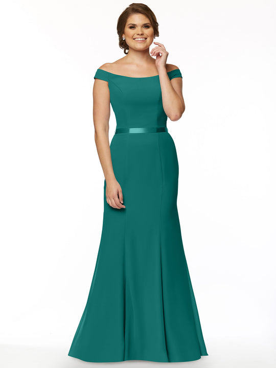 A woman models the Avery Austin 80079, an off-the-shoulder teal bridesmaid dress with a fitted bodice and flared, floor-length skirt, smiling as she stands against a plain white background.
