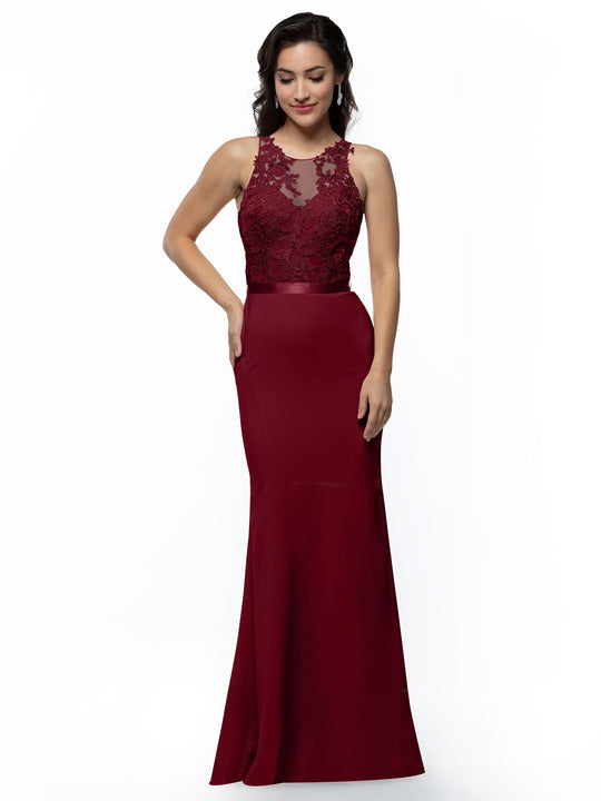A woman in Avery Austin’s burgundy 80095 bridesmaid dress—sleeveless, floor-length chiffon with a fit-and-flare silhouette, illusion lace bodice, and sheer neckline—stands smiling against a white background, hand on hip.
