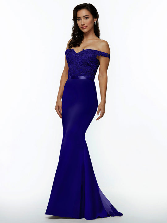 A woman models Avery Austin style 80104—a fitted off-the-shoulder bridesmaid dress with royal blue lace bodice and flared hem—against a white background. She has long dark hair and looks slightly to the side.