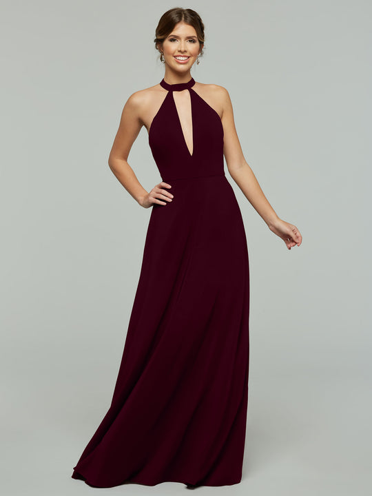 A woman wearing Avery Austin’s 80115— a sleeveless, floor-length dark burgundy halter A-line dress with a keyhole cutout—smiles against a plain gray background.