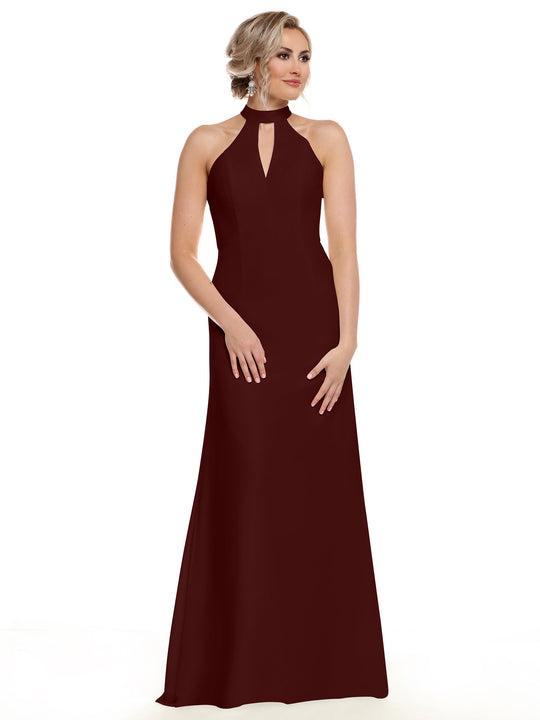 A woman in Avery Austin's 80138, a sleeveless, floor-length maroon gown with an open back and keyhole halter neckline, stands against a white background. Her light hair is styled in an elegant updo as she looks slightly to the side.