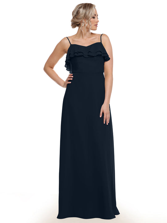 A woman models Avery Austin’s 80146—a sleeveless, floor-length black chiffon A-Line dress with tiered ruffles—standing against a plain white background and looking to the side with one hand on her hip.