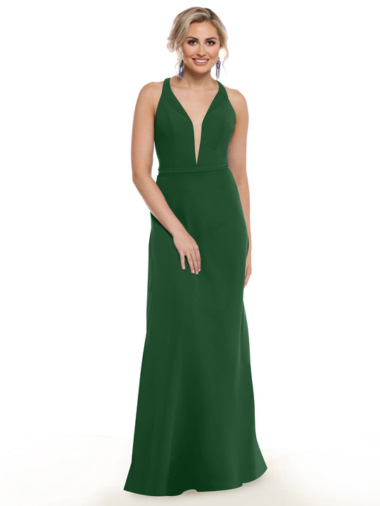A woman models Avery Austin's floor-length, sleeveless gown (style 80150) with a plunging neckline and geometric cut-outs, smiling against a plain white background with one hand on her waist.