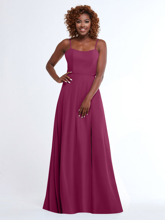 A woman with curly hair smiles in the Avery Austin 80170, a flowy magenta A-line dress with spaghetti straps, against a plain white background.