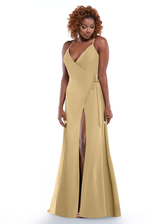 A woman with curly hair wears the Avery Austin 80171, a light tan dress featuring thin straps, a deep V-neckline, and a high front slit. She stands against a white background, looking down with a gentle expression.
