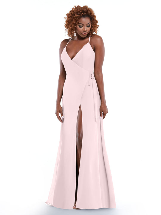 A woman with curly hair wears the Avery Austin 80171, a pale pink sleeveless slit dress with thin straps and a self-tie sash, standing against a plain white background.