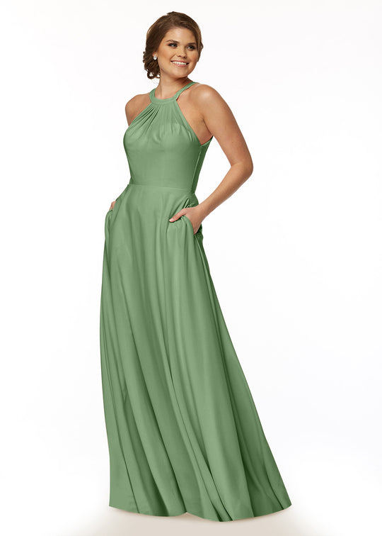 A woman models Avery Austin’s 83002—a sleeveless, floor-length sage green A-line dress with a halter neck and pocketed flowy skirt—smiling and looking to the side against a plain white background.
