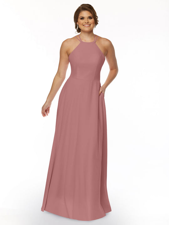 A woman smiles in Avery Austin’s 83006—a sleeveless, floor-length dusty rose A-line dress with a halter neckline and fitted bodice—posing against a plain white background.