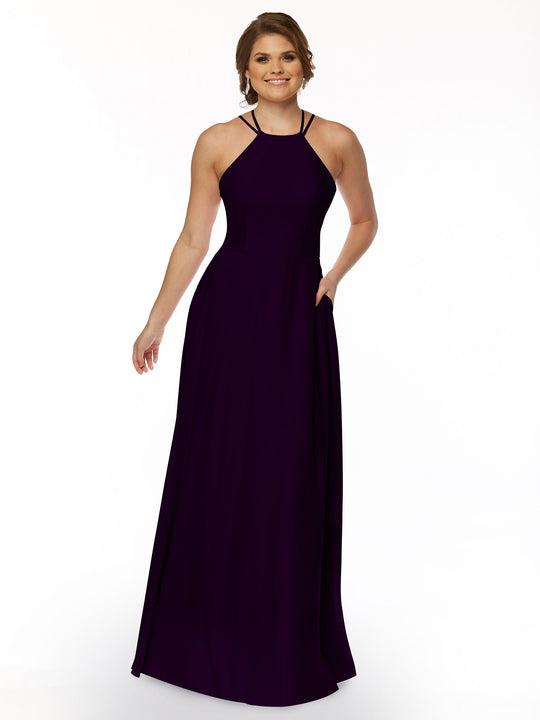 A woman smiles in Avery Austin's 83006—a sleeveless, floor-length A-Line dress featuring a halter neckline and pockets—against a plain white background.