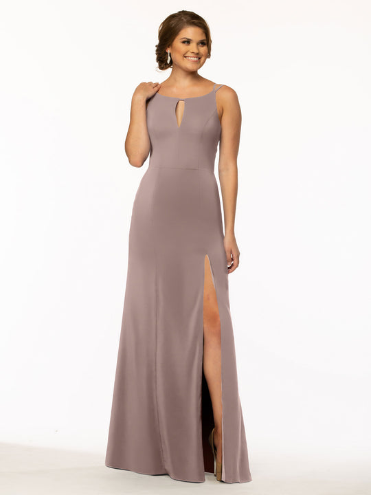 A woman in the Avery Austin 83030 sleeveless mauve sheath dress with a front keyhole cutout, high slit skirt, and bateau neck stands smiling against a plain white background.