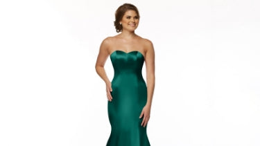 Woman wearing an emerald green bridesmaid dress on a white background.