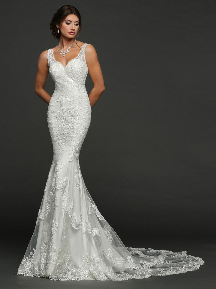 A woman in the Avery Austin Evelyn (Testing) fitted, sleeveless lace wedding dress with a long train stands against a dark background, wearing a pearl necklace and an updo, gazing softly to the side.