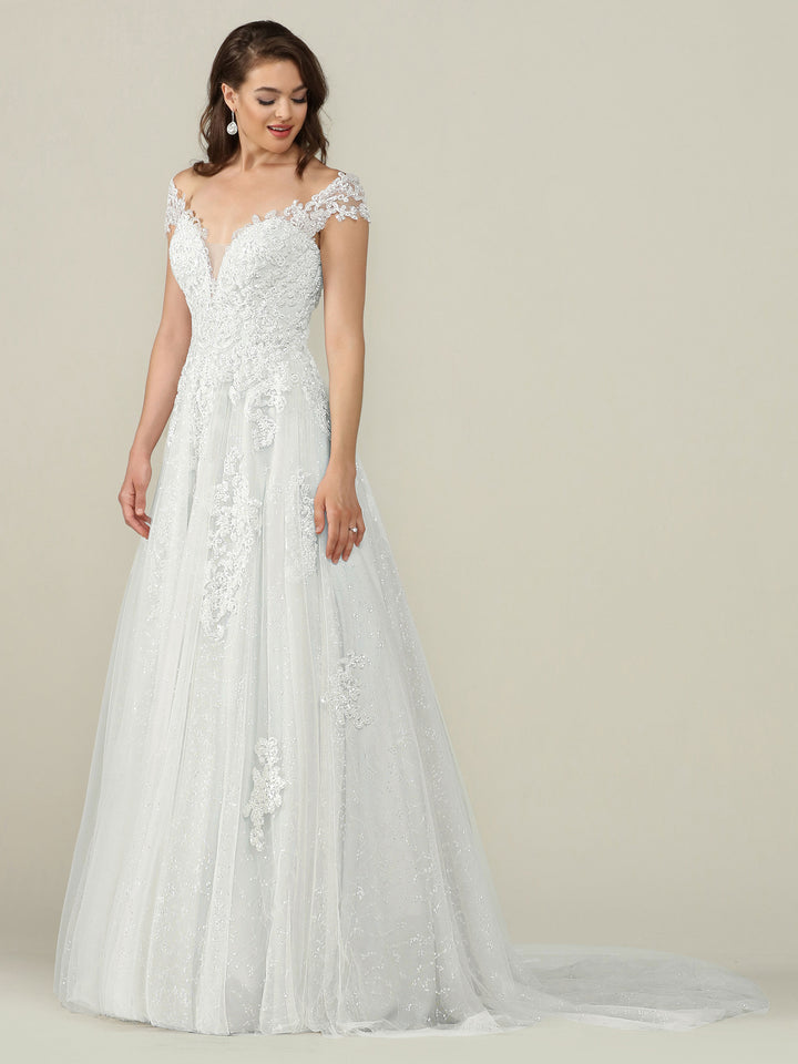 A woman poses against a plain light background wearing the Avery Austin TH-Piper wedding dress in Ivory/Ivory, featuring an elegant off-the-shoulder lace bodice and flowing tulle skirt. Her long brown hair and delicate earrings complete the look.