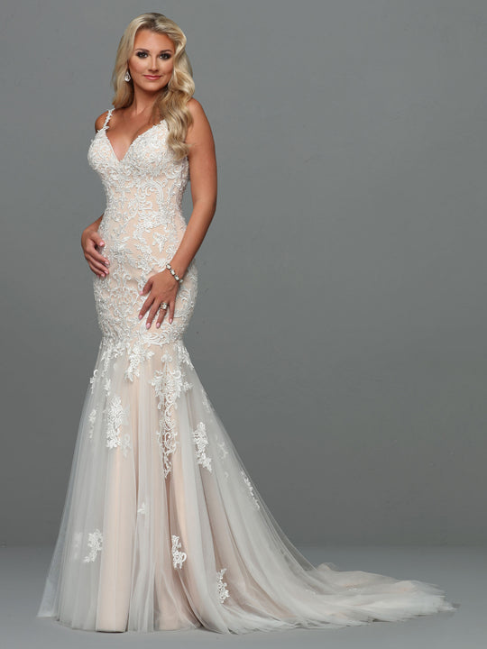 A woman models the Alexandra - Tried On Sample by Avery Austin in Ivory/Nude, a fitted, sleeveless, backless wedding dress with lace appliqué and tulle skirt, posing against a gray background.