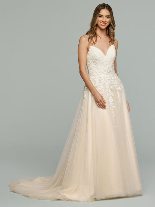 A woman smiles against a plain gray background wearing the Vanessa - Tried On Sample by averyaustin, an A-line wedding dress featuring a sweetheart neckline, floral lace appliques on the bodice, and a flowing tulle skirt.