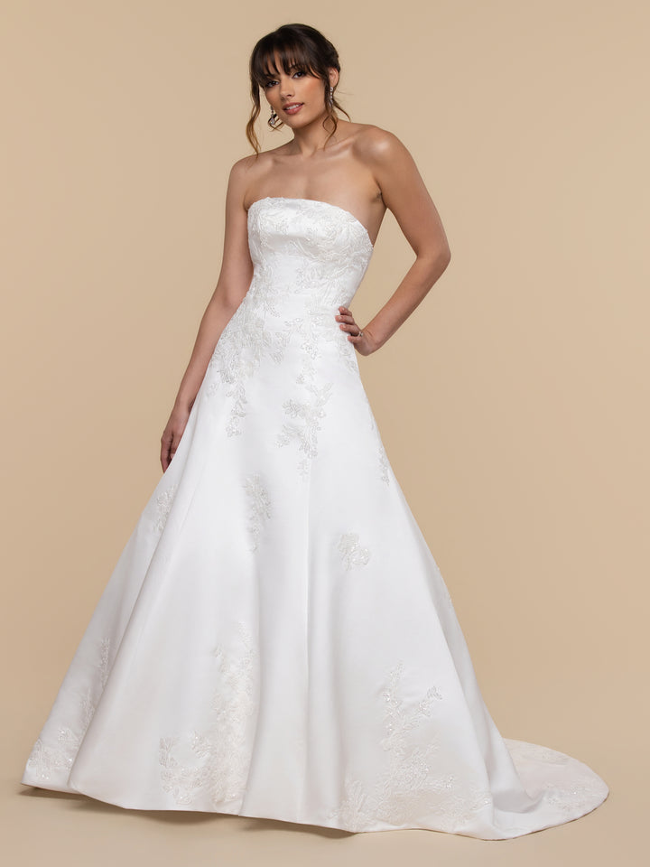 The Eloise averyaustin strapless, diamond white A-line wedding dress features delicate floral embroidery on the bodice and skirt.