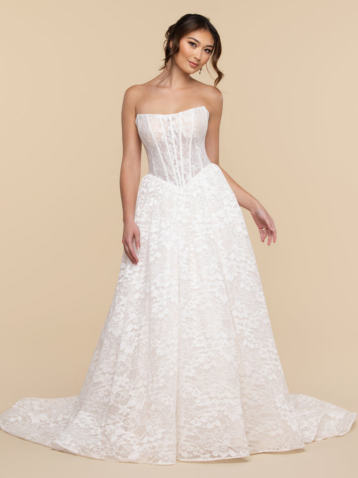 The Wren wedding dress by averyaustin features a strapless, floor-length design with a corset bodice and a full Chantilly lace skirt.