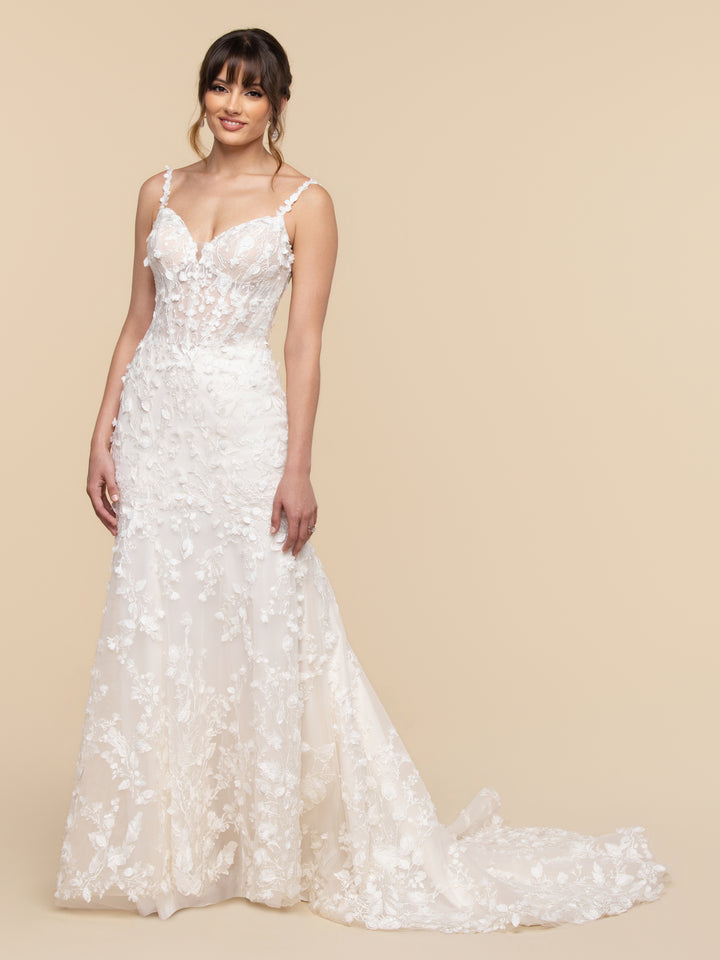 AveryAustin Alessandra ivory and nude sleeveless fit-and-flare wedding dress featuring a sheer bodice, plunging neckline, and floral appliques throughout the lace and tulle skirt and train.