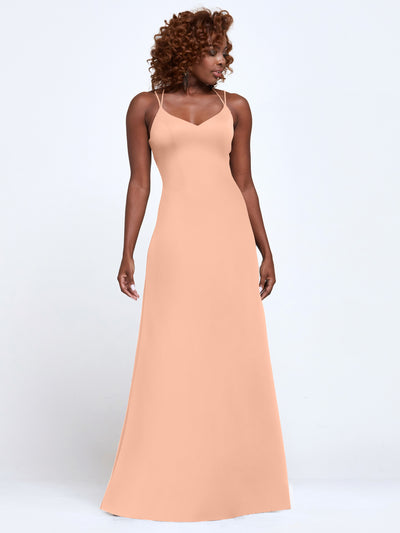 A woman with curly hair wears the Avery Austin 83045, a floor-length A-Line dress with spaghetti straps in Petal Pink, standing against a plain white background.