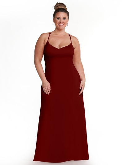 A woman with her hair in a bun is wearing the Avery Austin 83045 burgundy A-line dress. She is standing and smiling against a plain white background.