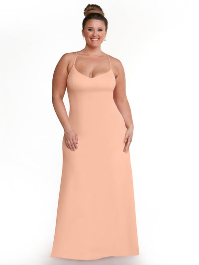 A smiling woman with light brown hair in a bun models Avery Austin 83045, a sleeveless Petal Pink A-Line dress with spaghetti straps, standing against a plain white background.