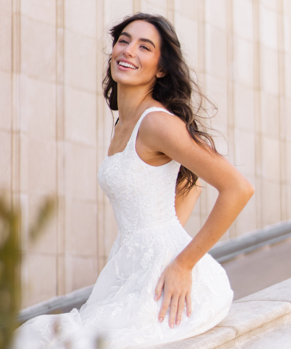 Woman in a white dress sitting outdoors with a blurred background