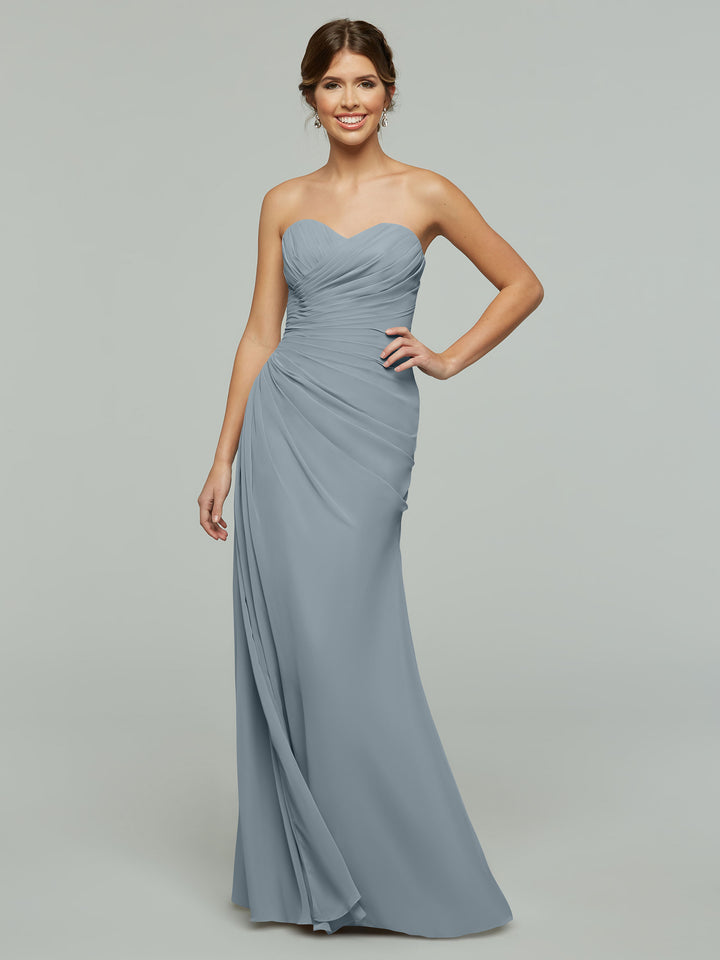 Model wearing Avery Austin 80028, a strapless, floor-length chiffon gown with ruched details and a subtle sweetheart neckline, poses against a plain gray background.