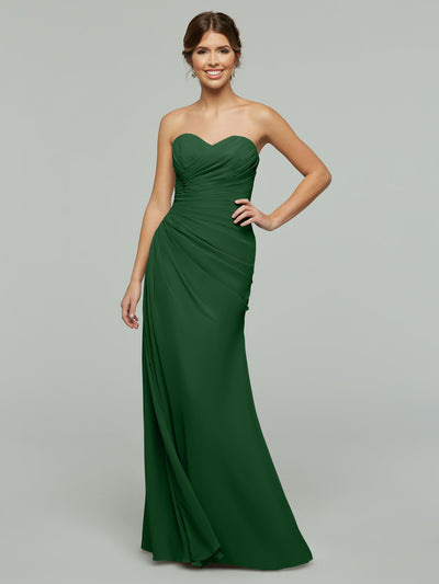 A woman poses against a plain gray background wearing Avery Austin's 80028, a strapless chiffon gown with ruched detailing and a sweetheart neckline.