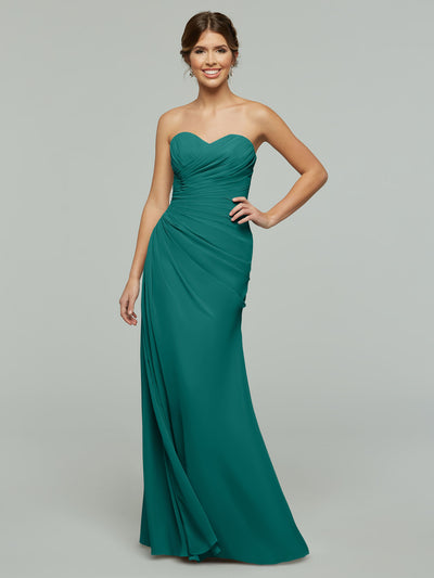 A woman models Avery Austin’s Teal 80028: a strapless chiffon gown with a sweetheart neckline and gathered details, standing before a plain light gray background.