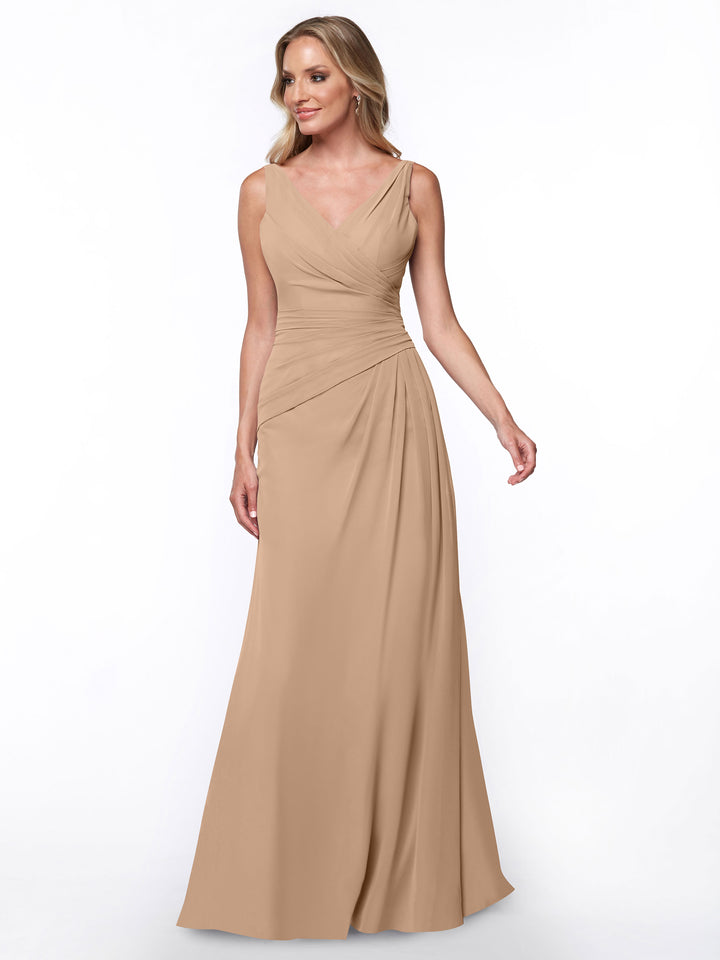 A woman stands against a white background wearing the Avery Austin 80030 sheath dress in Buff, featuring a sleeveless, floor-length design with a V-neck and ruched bodice.