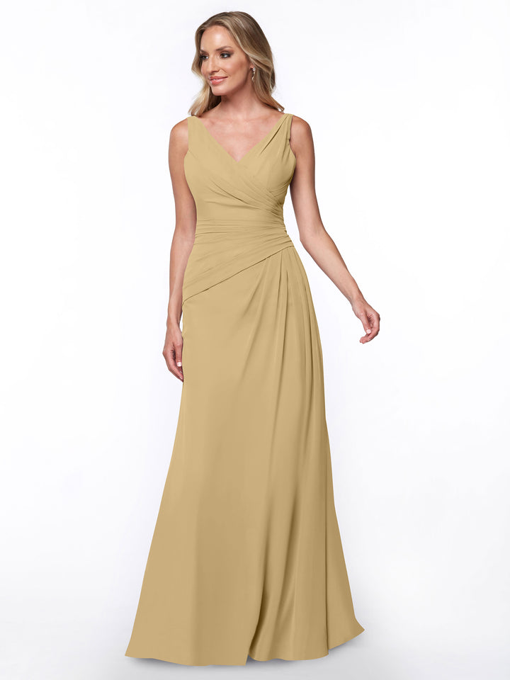 A woman wearing the Avery Austin 80030 sheath dress in champagne, featuring a V-neck and ruched bodice, stands against a white background, smiling and looking slightly to her left.