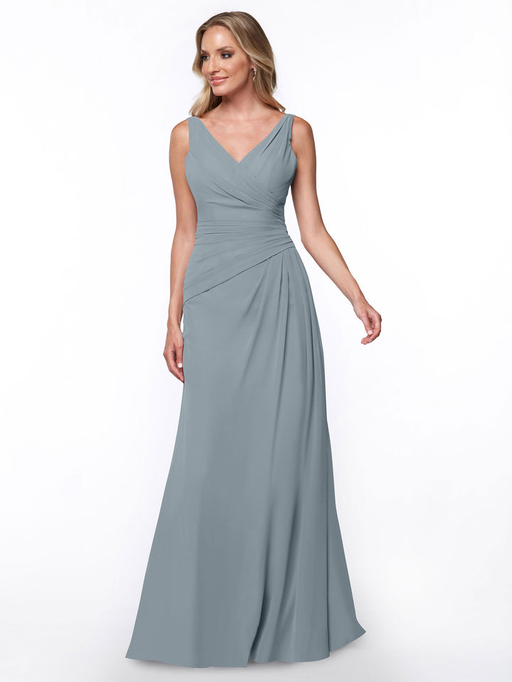 A woman with light brown hair wears the Avery Austin TH-80030, a slate blue sleeveless floor-length sheath dress featuring a ruched bodice and V-neckline, standing against a plain white background.