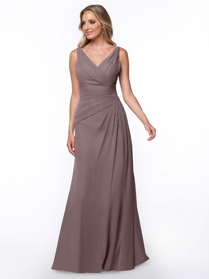 A woman stands against a plain white background wearing Avery Austin’s 80030, a mauve sleeveless, floor-length sheath dress with a V-neckline and ruched bodice.