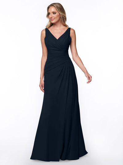 A woman models Avery Austin’s 80030, a sleeveless, floor-length navy blue sheath dress with a V-neckline and ruched bodice, standing against a plain white background.