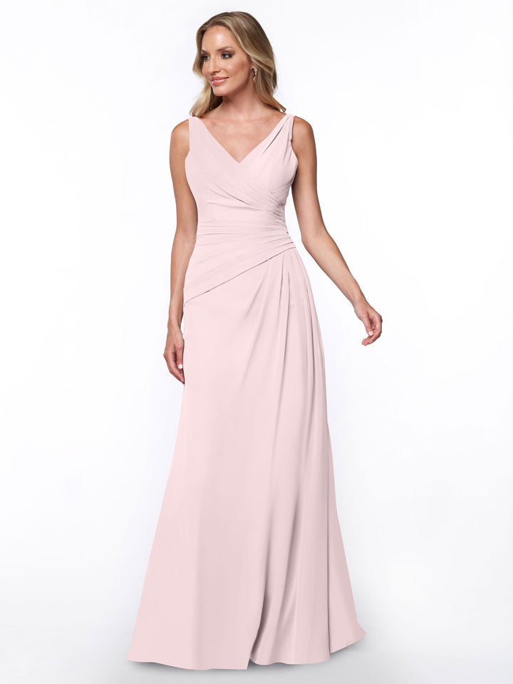 A woman models the Avery Austin TH-80030, a long light pink sheath dress with a V-neck and ruched bodice, standing against a plain white background.