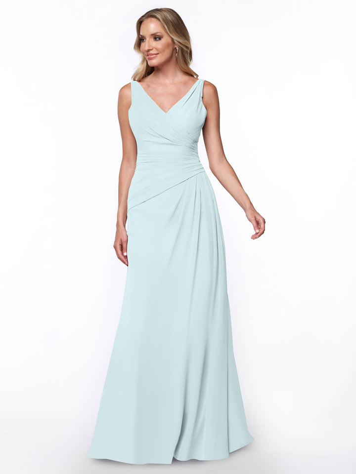 A woman models Avery Austin’s 80030: a sleeveless, light blue, floor-length sheath dress with a V-neckline and ruched bodice, standing against a plain white background.