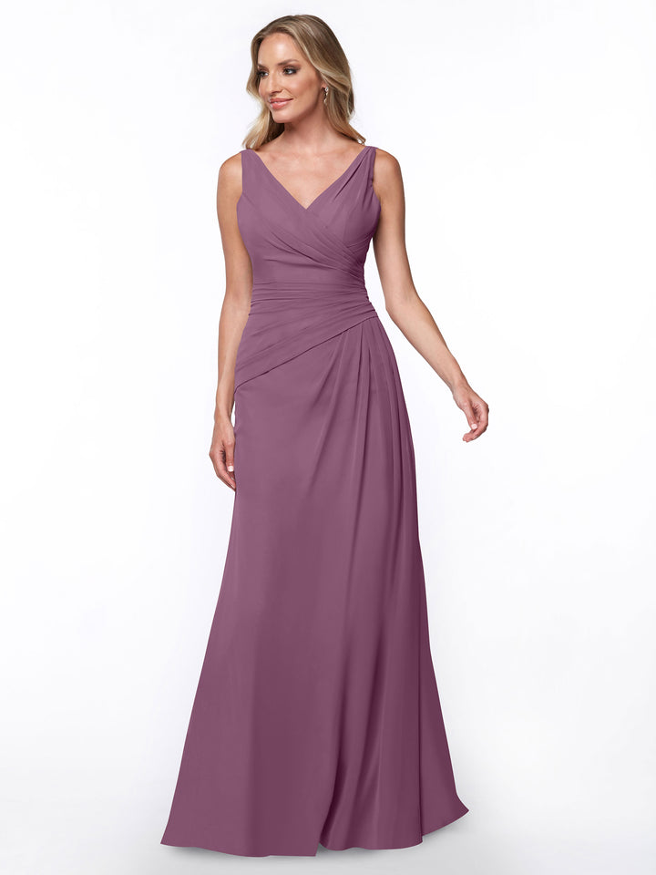 A woman models Avery Austin’s 80030: a sleeveless, floor-length mauve sheath dress with a V-neckline and ruched bodice, standing against a plain white background.