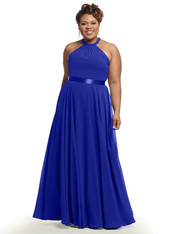 A smiling woman wears Avery Austin’s 80038 sleeveless cobalt A-line chiffon dress with a halter neckline, satin waistband, and pleated skirt, standing against a white background.