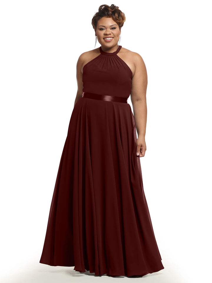 A woman in Avery Austin’s merlot sleeveless chiffon floor-length A-Line dress (style 80038) with halter neckline and satin waistband, smiling against a plain white background.
