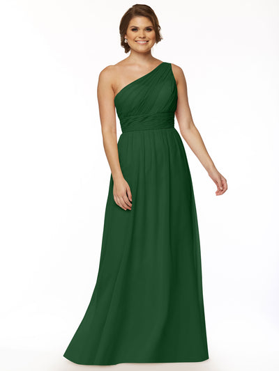 A woman smiles against a white background in Avery Austin style 80047, a floor-length dark green one-shoulder chiffon dress with a ruched bodice. Her hair is styled in loose waves, and she wears earrings.
