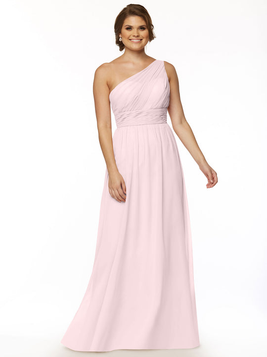 A woman in Avery Austin’s TH-80047 dress in Rose Petal stands smiling against a white background. The light pink, floor-length chiffon gown features a one-shoulder design, fitted ruched bodice, and flowing skirt.
