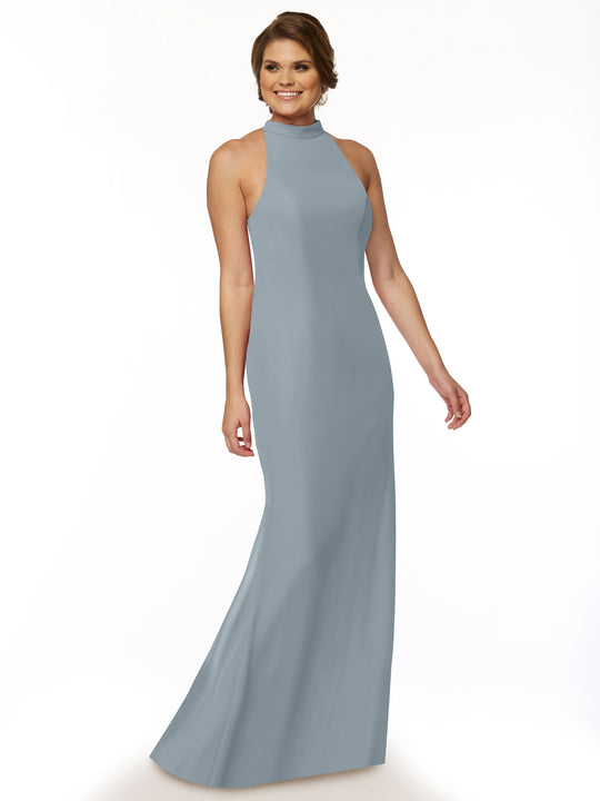 A woman smiles against a white background, modeling Avery Austin's 80068 sleeveless light blue halter bridesmaid dress with a high neckline.