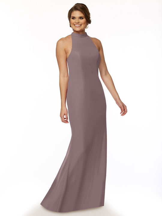A woman with short brown hair smiles while modeling Avery Austin’s mauve chiffon bridesmaid dress, style 80068, featuring a high neckline, against a plain white background.